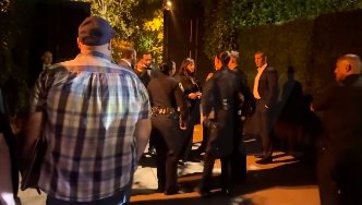 Police officers speaking with security as bystanders and guests look on, posted on November 9, 2025. | Source: Instagram/tmz_tv