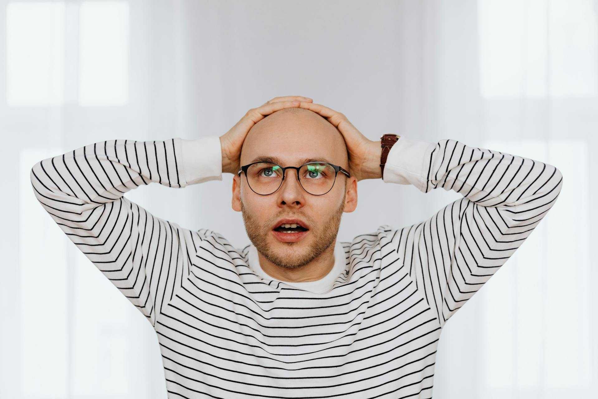 A surprised man holding his head | Source: Pexels