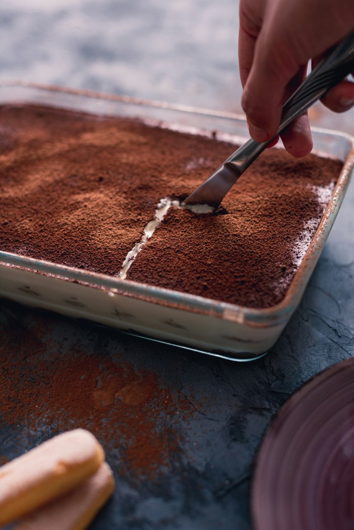 A person cutting a slice of tiramisu | Source: Unsplash