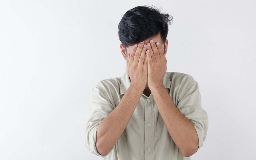 An upset man covering his face with his hands | Source: Pexels
