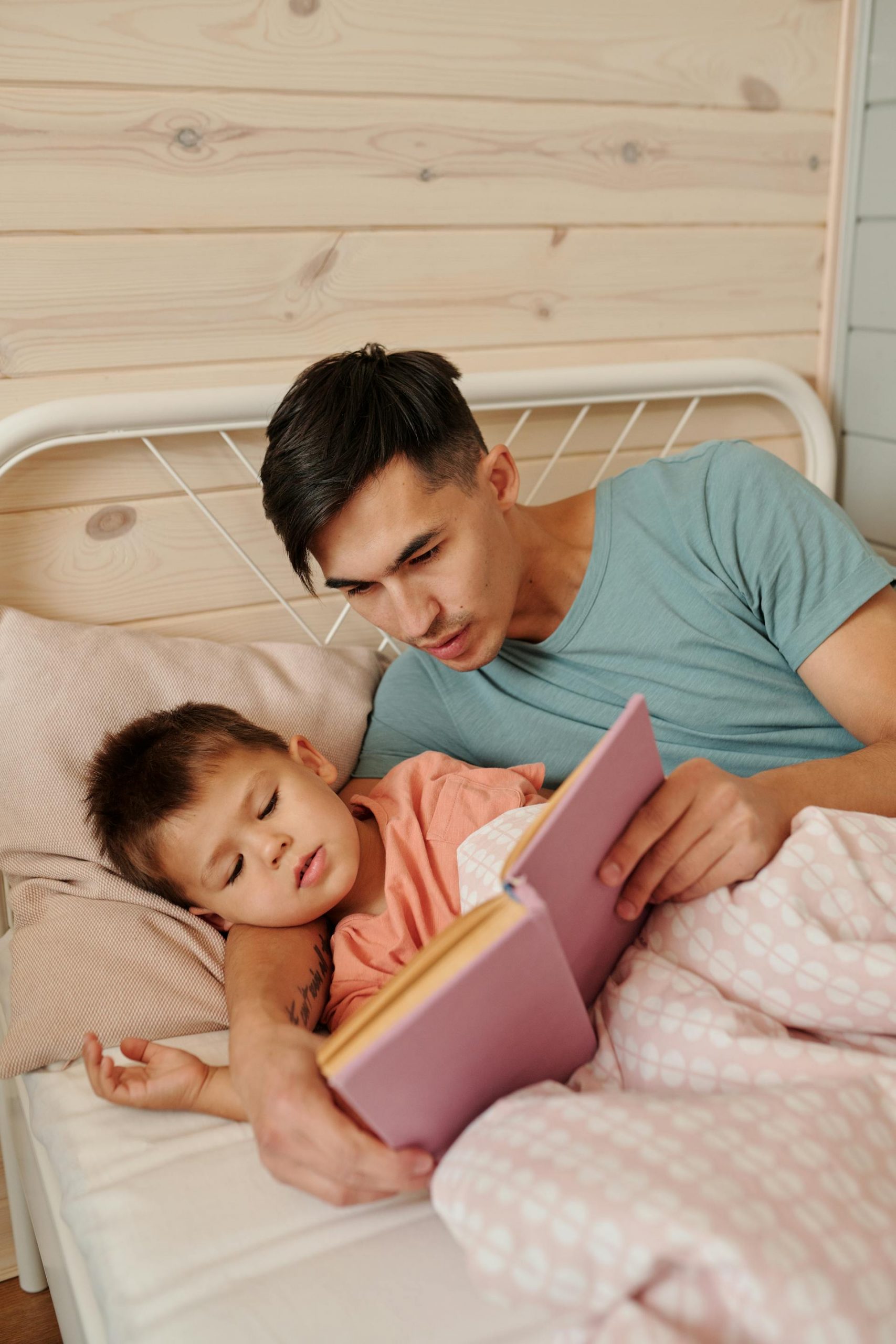 A man reading a bedtime story to his son | Source: Pexels