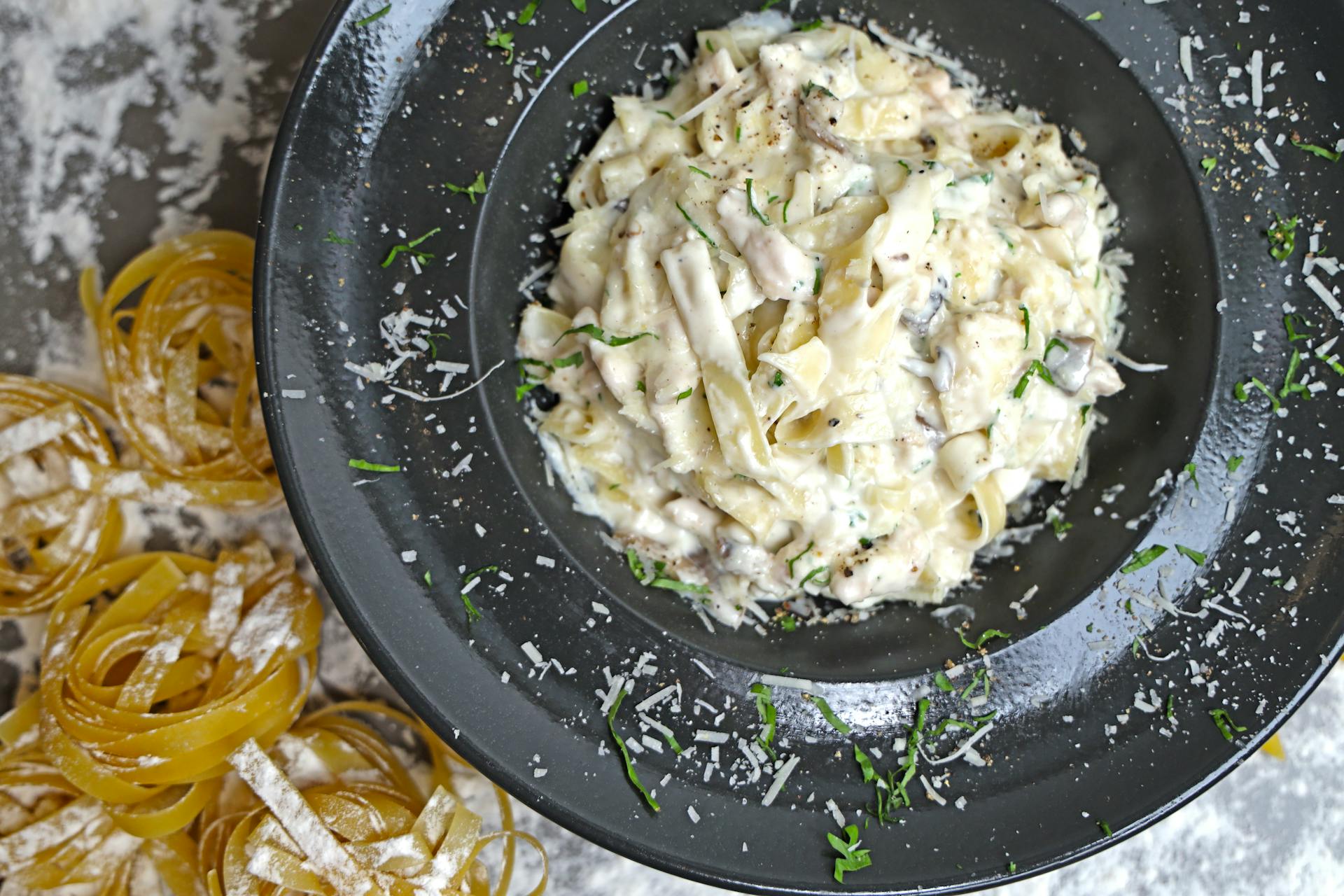 A bowl of pasta with chicken and cheese on top | Source: Pexels
