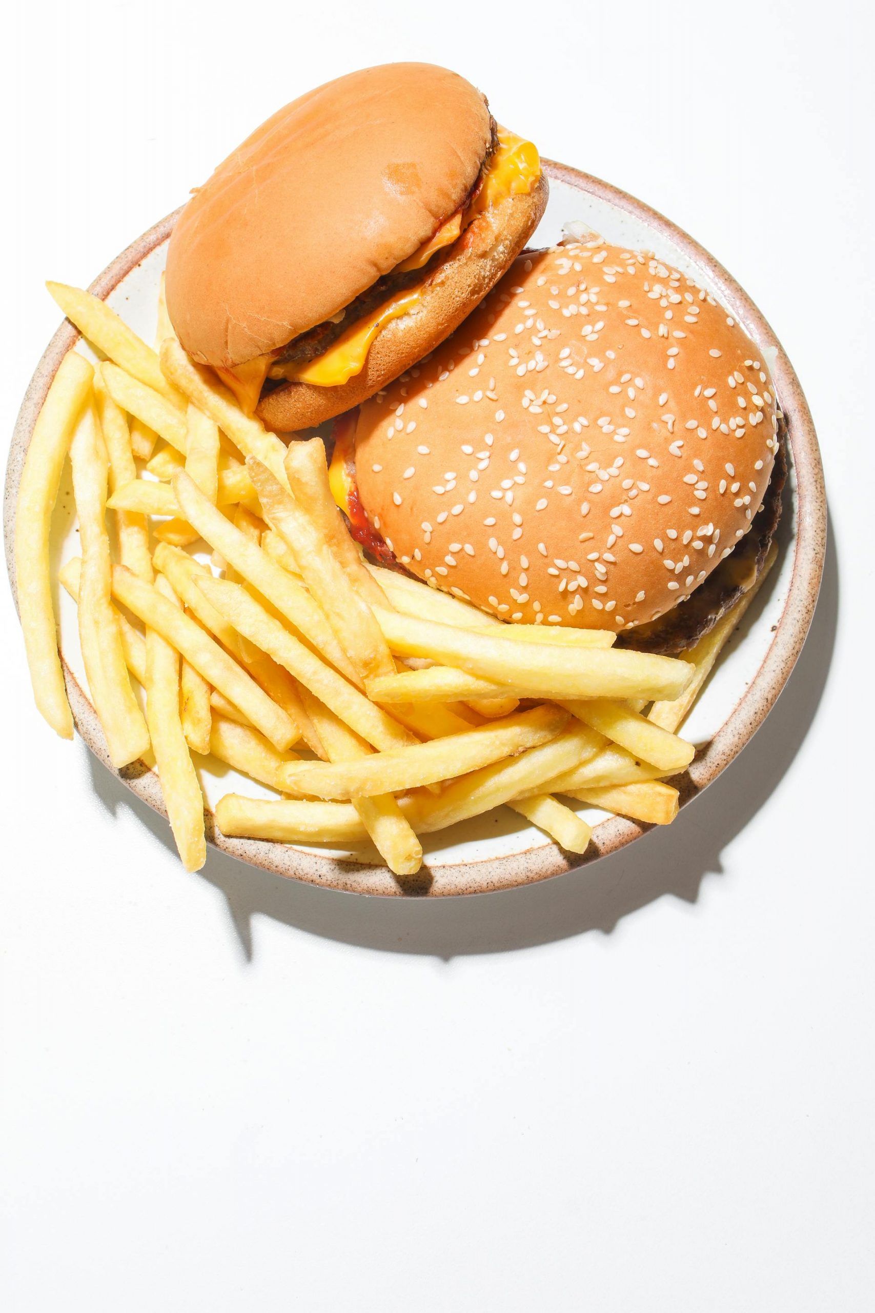 Burgers and fries served on a plate | Source: Pexels