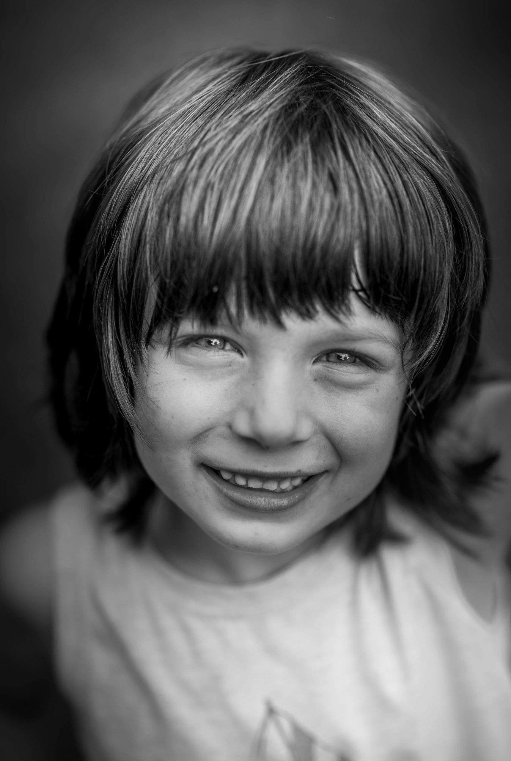 A grayscale photo of a young boy smiling | Source: Pexels