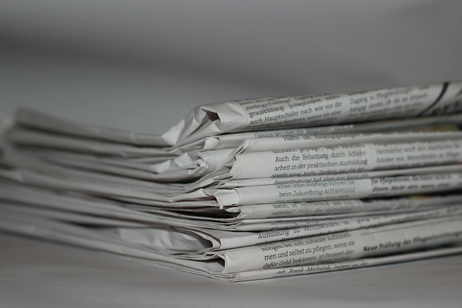 Newspapers stacked on a table | Source: Pexels