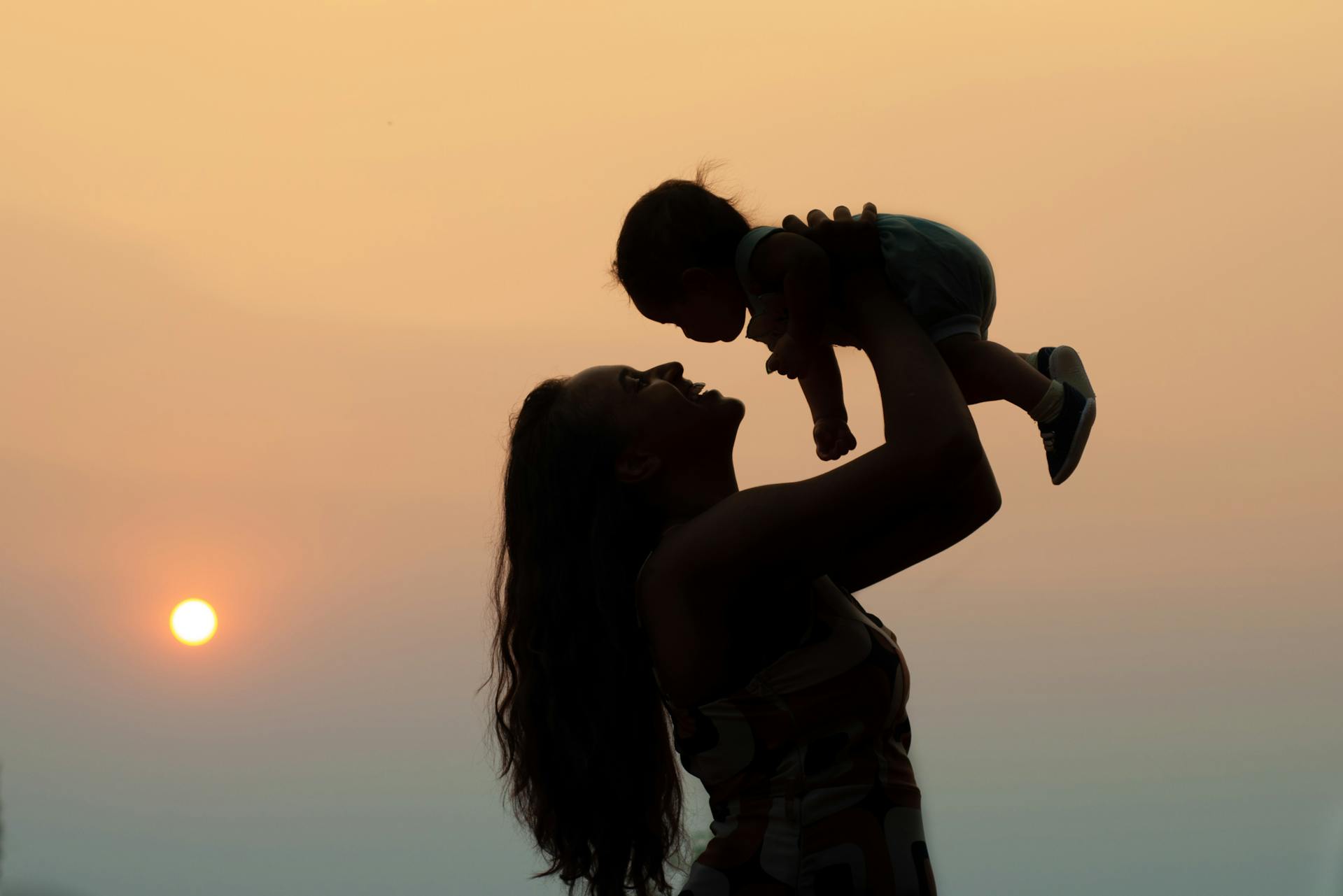 Silhouette of a woman carrying a baby | Source: Pexels