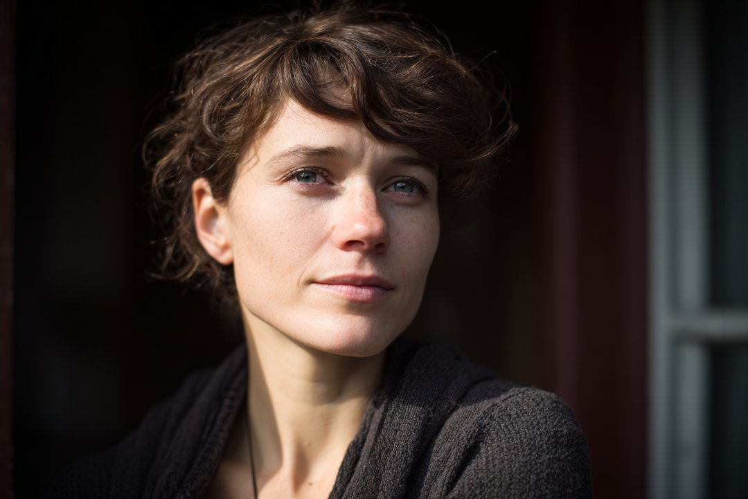 A woman standing outside her house | Source: Midjourney