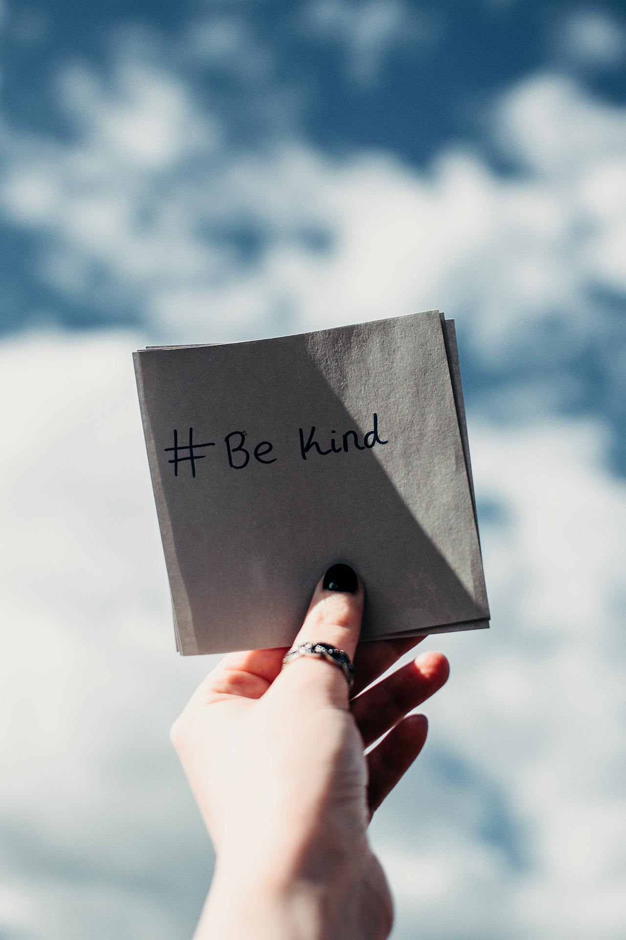 A woman holding a piece of paper bearing a message | Source: Pexels