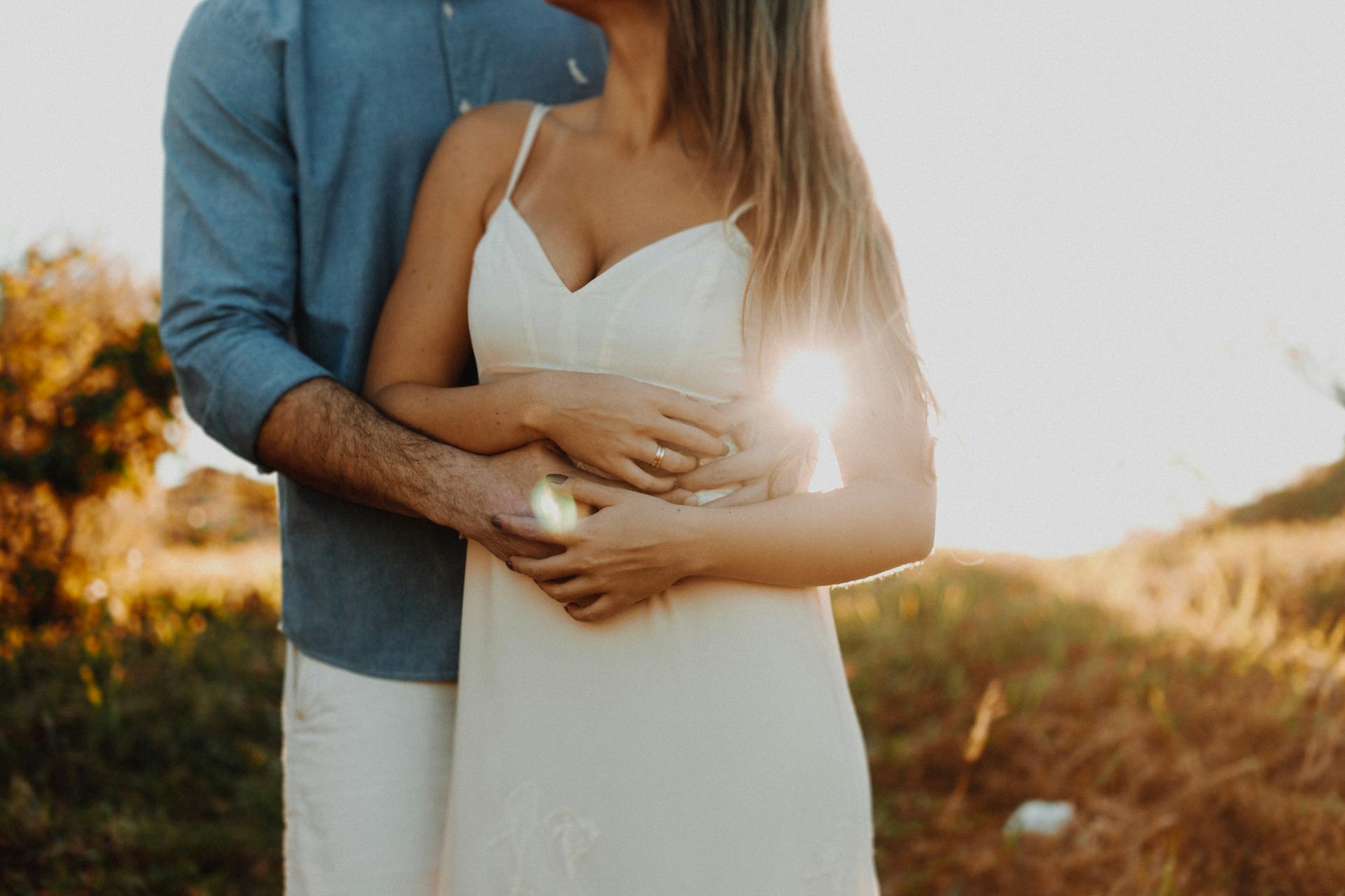 Close-up shot of a man holding a woman in a white dress | Source: Pexels