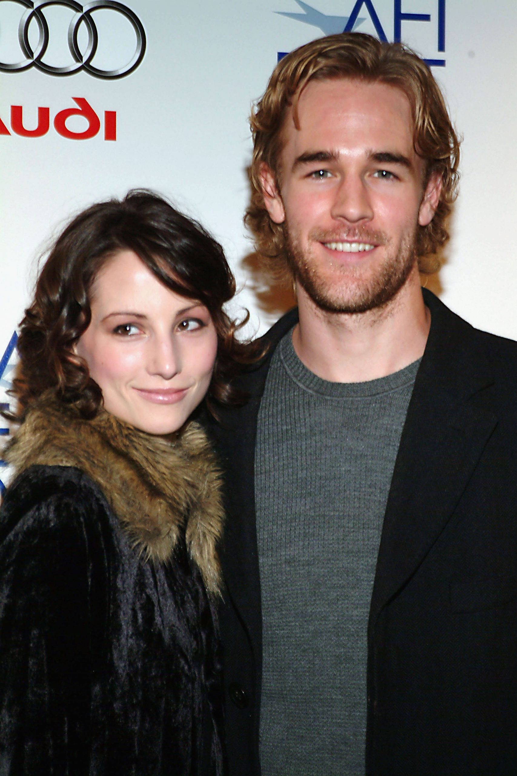 James Van Der Beek arrives at the AFI Fest with a relaxed smile in a sweater and blazer. Heather McComb stands beside him in a black fur-trimmed coat, her curls and serene smile adding elegance. Together, they exude calm sophistication at the RX premiere.