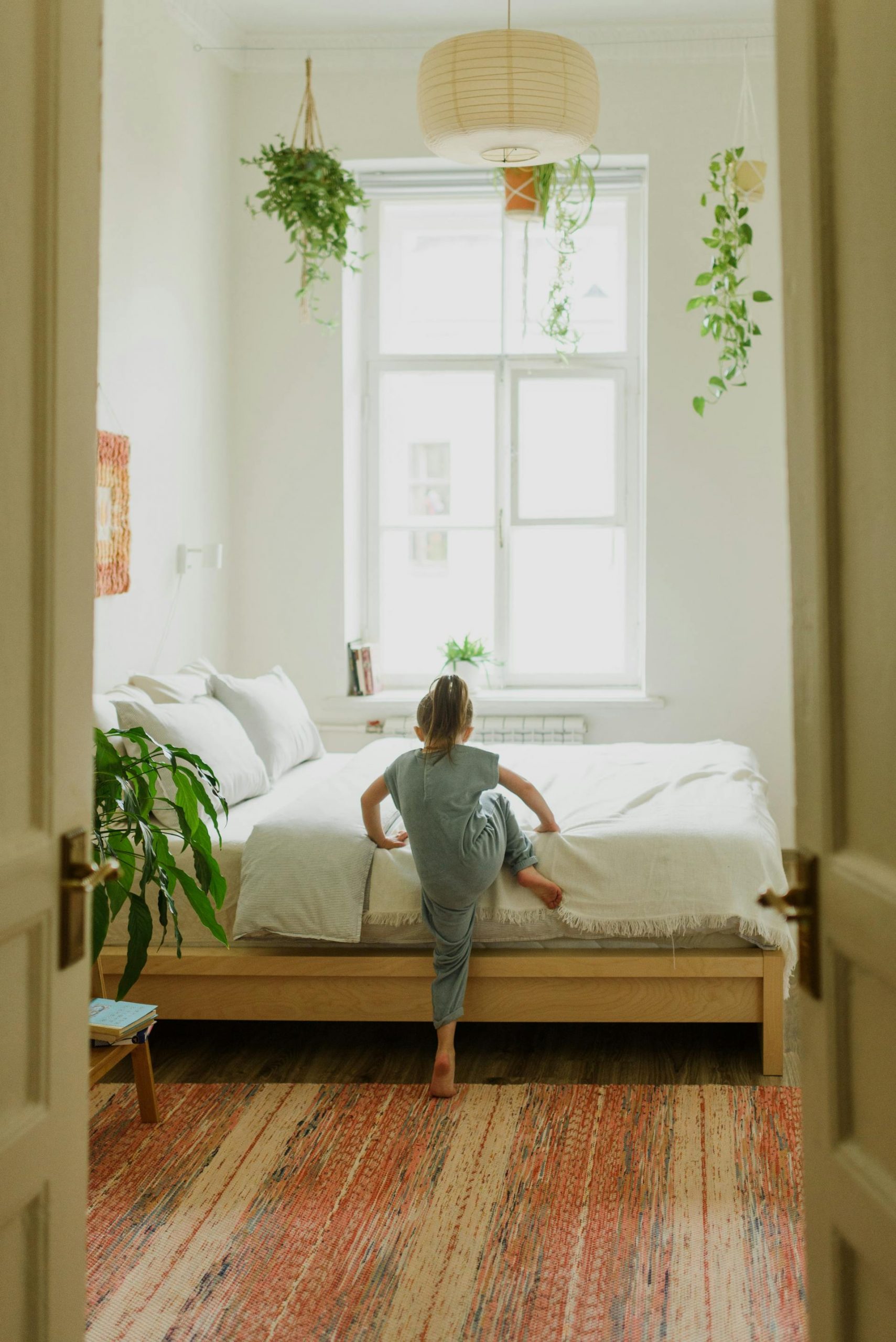A little girl climbing into bed | Source: Pexels