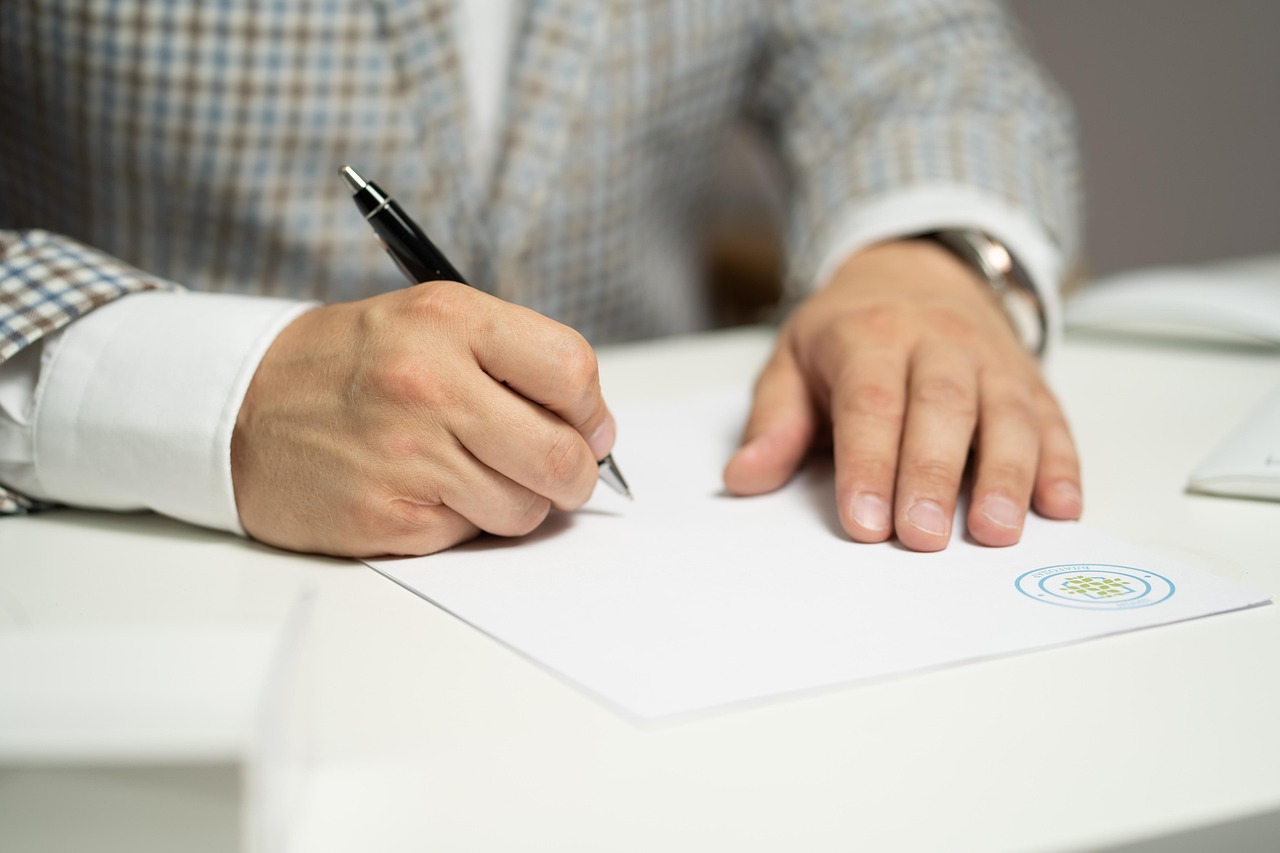 A man signing a document | Source: Pixabay