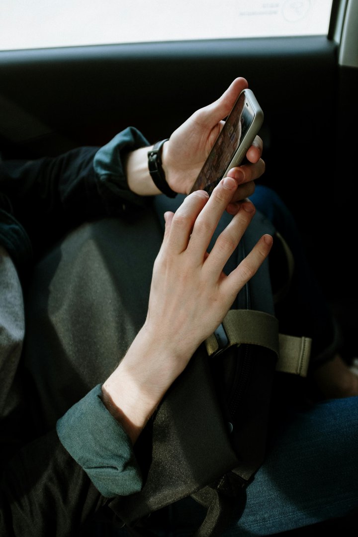 A person holding a cellphone in a car | Source: Pexels