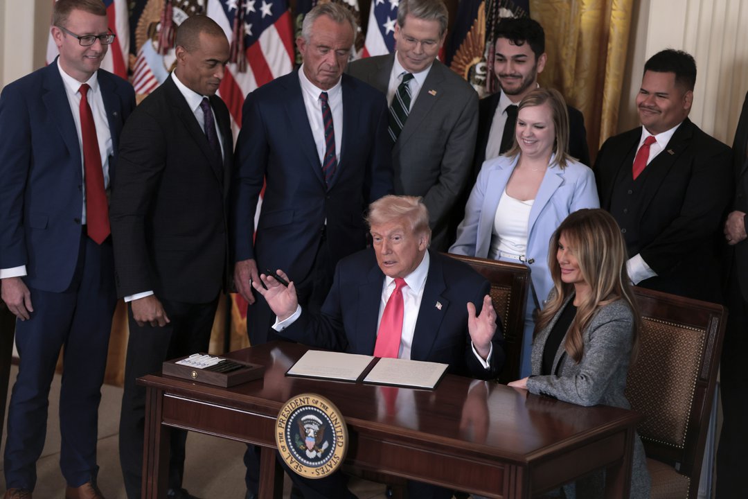 Donald Trump joined by Melania Trump and members of his administration and foster care advocates during the signing of an executive order on foster children and families on November 13, 2025 | Source: Getty Images