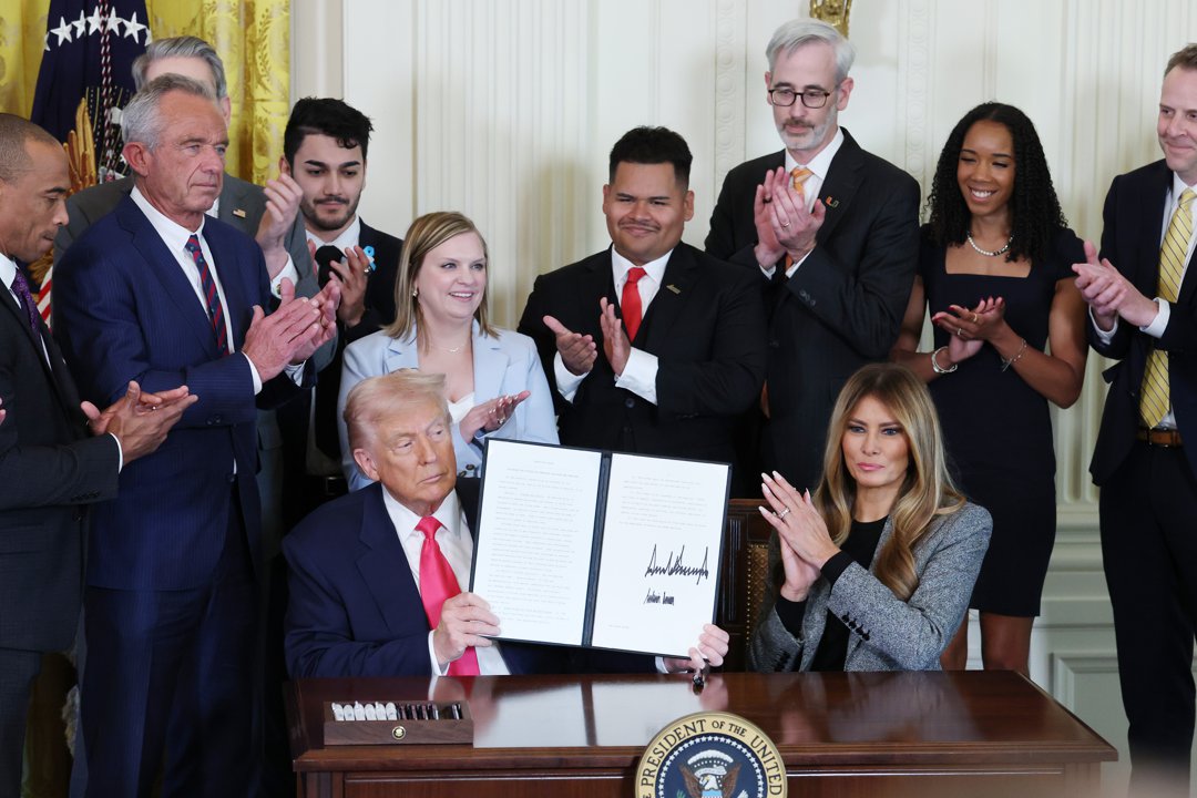 Donald Trump joined by Melania Trump and members of his administration and foster care advocates, signs the 