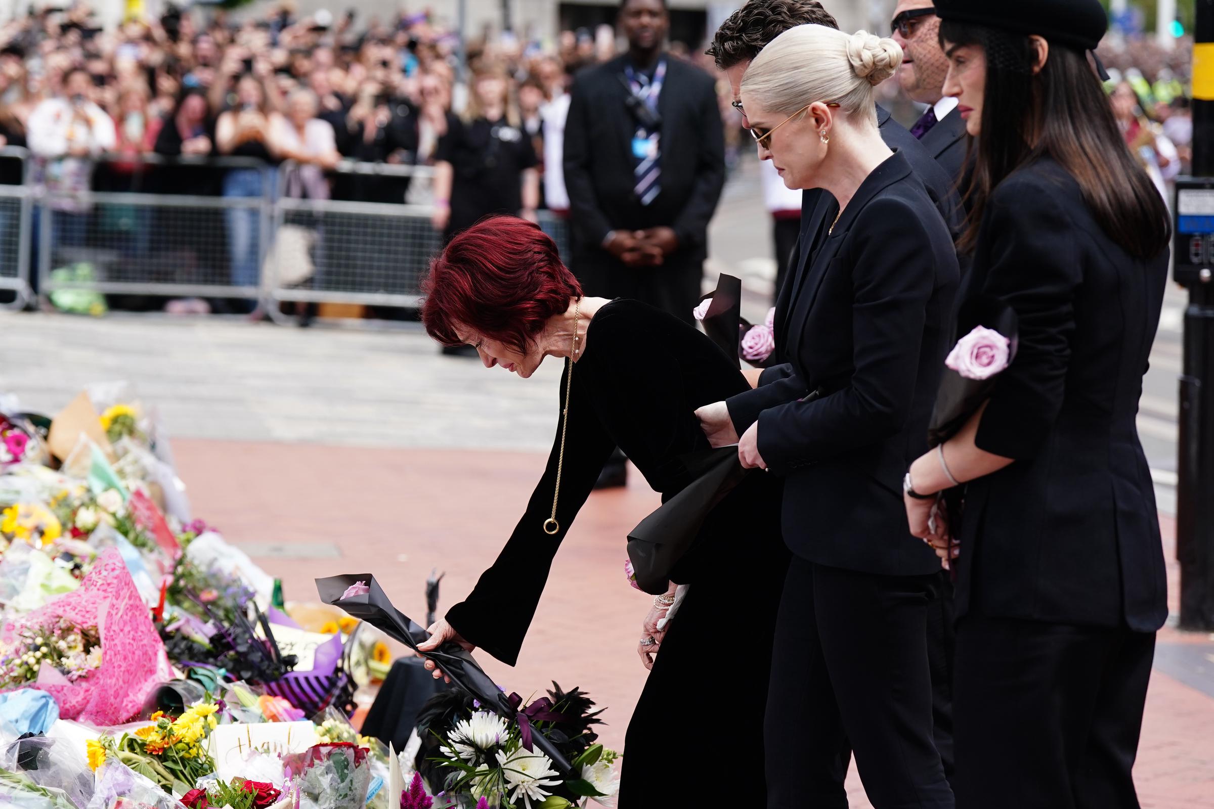 The Osbourne family view the messages and floral tributes left at the Black Sabbath Bridge in Birmingham on July 30, 2025 | Source: Getty Images