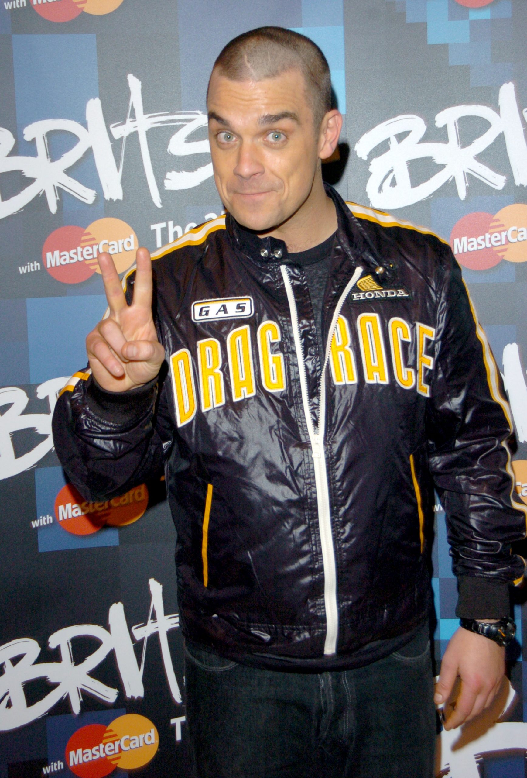 Robbie Williams posed at the 2005 Brit Awards flashing a peace sign in a bold
