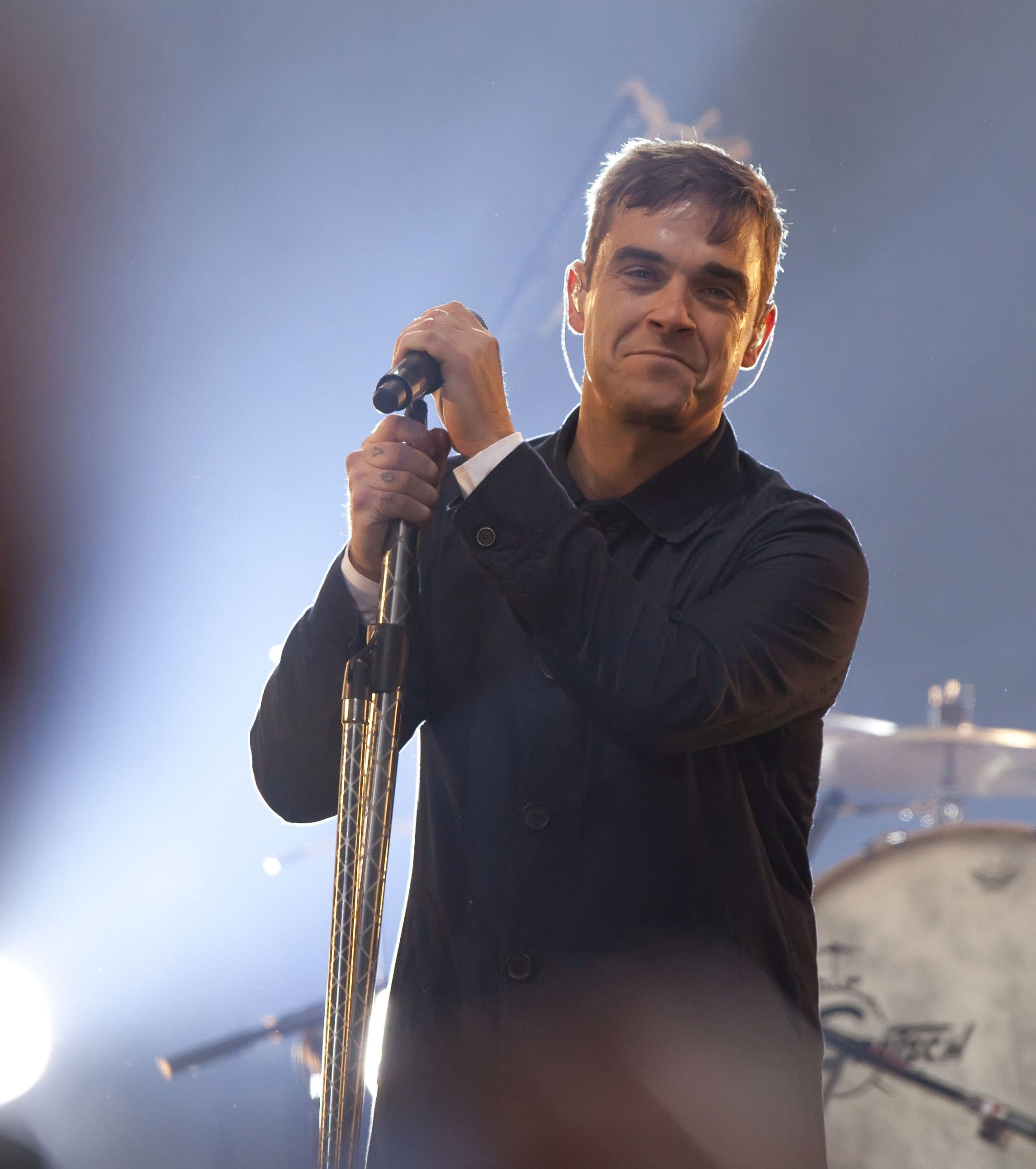 Robbie Williams performed live during a free pop-up gig in Berlin, Germany, on October 23, 2009. Gripping the mic stand with a grin, he delivered an intimate show that brought fans close to the high-energy charisma that defined his live performances.