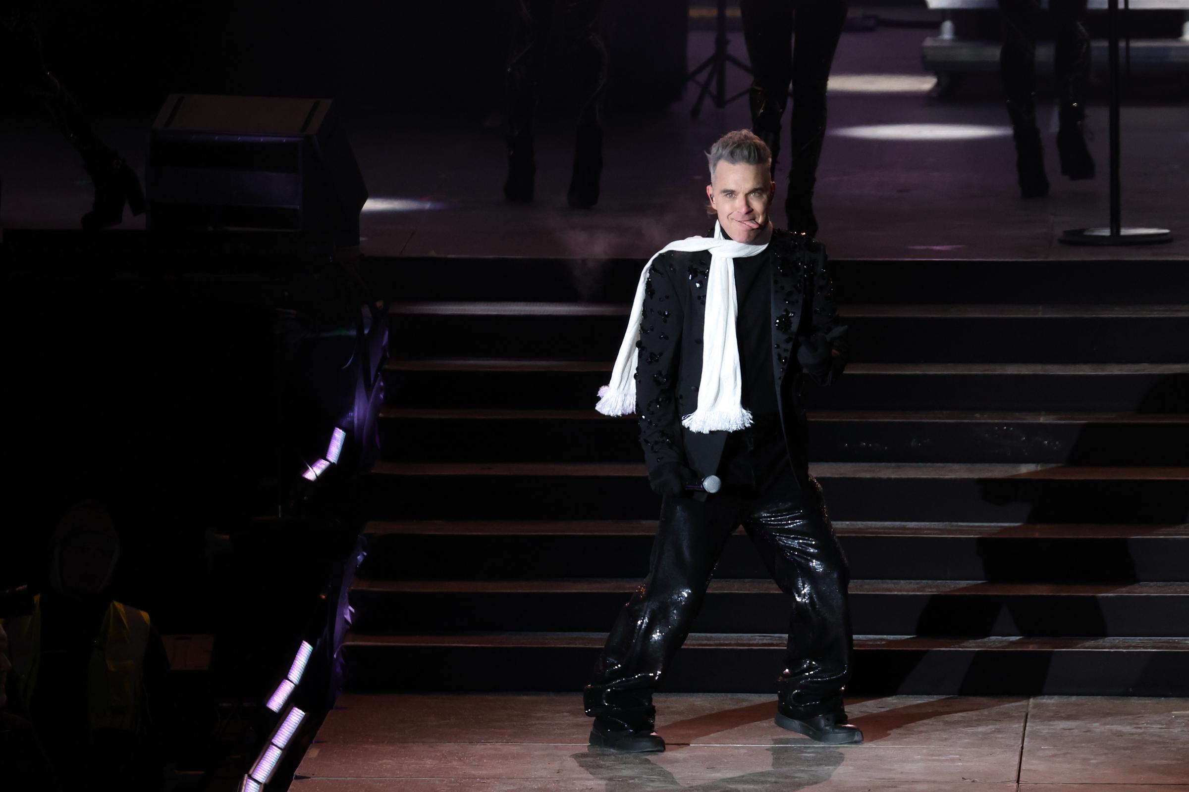 Robbie Williams performed at the Schladming-Dachstein ski opening concert on December 7, 2023, in Austria. Bundled in a beaded black outfit and white winter scarf, he brought his trademark flair to the frosty alpine stage.