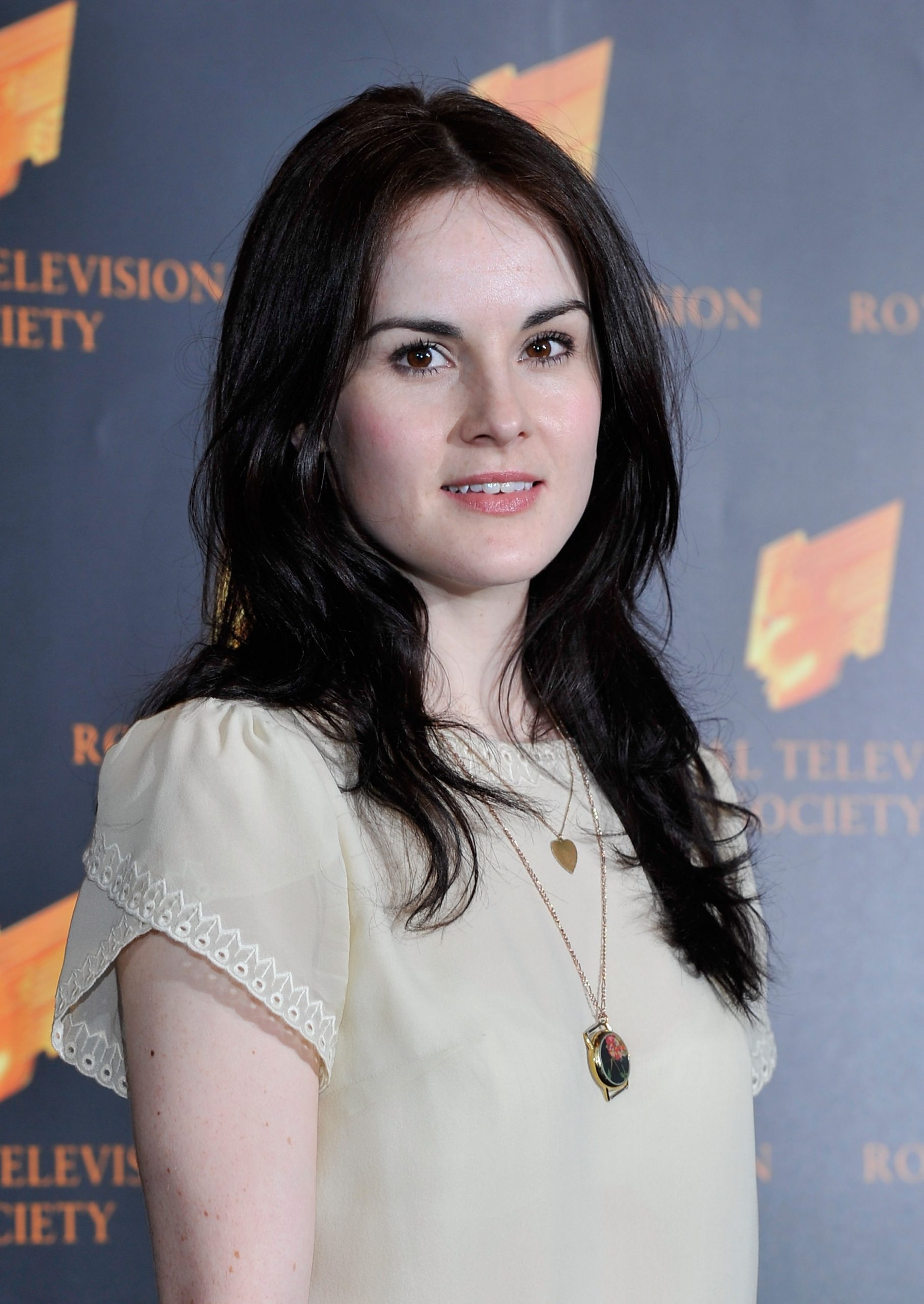 Michelle Dockery attended the RTS Programme Awards in 2011 with a natural, youthful look. Wearing a soft cream blouse and minimal makeup, she radiated quiet elegance — a fitting mirror to her breakout role as the poised and complex Lady Mary on