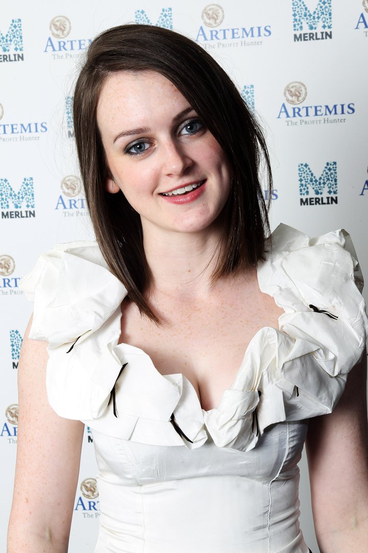 Sophie McShera attended the 2011 Merlin Medical Relief charity event with a fresh-faced charm, wearing a playful white dress with ruffled shoulders. Her straight brunette hair and minimal makeup gave her a youthful, down-to-earth presence that contrasted her on-screen role as the kitchen maid Daisy.
