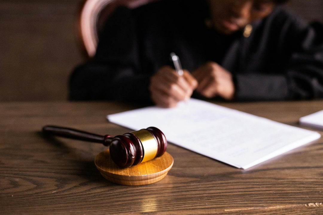 A judge filling out paperwork | Source: Pexels