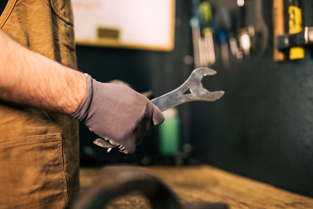 A man holding a spanner | Source: Freepik
