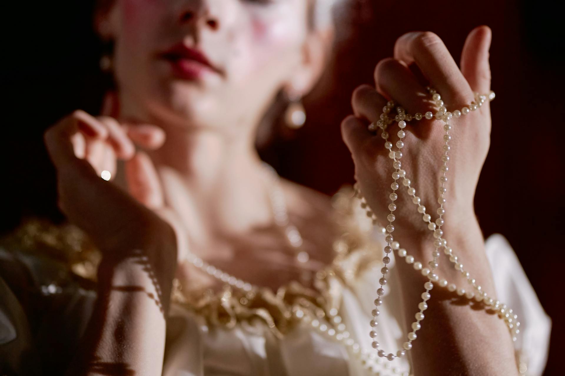 A wealthy woman fidgeting with pearl strings | Source: Pexels