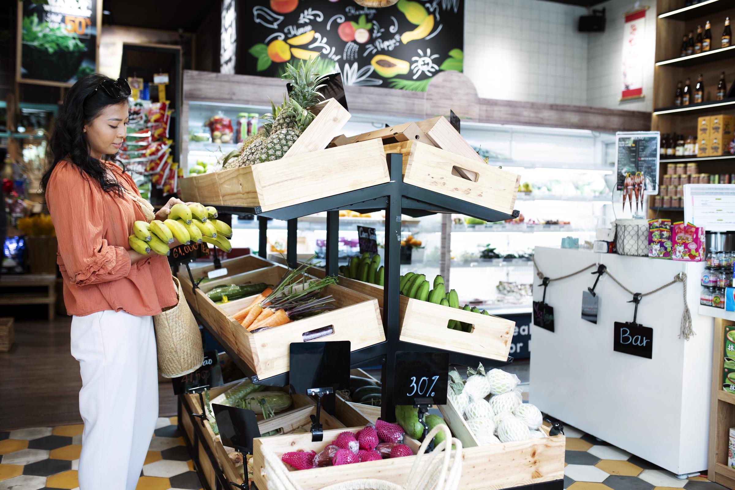 A woman buying produce in a small grocery store | Source: Freepik