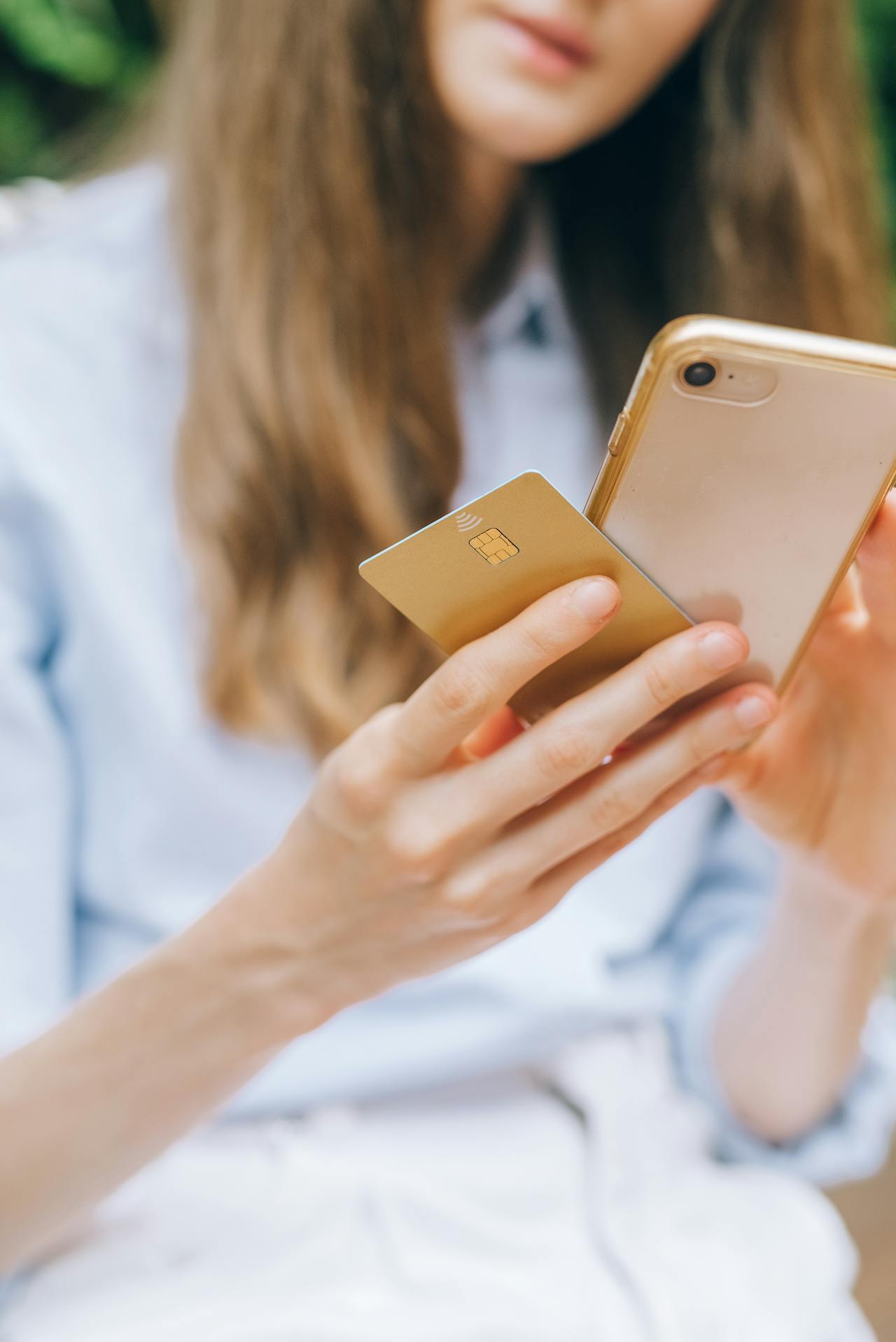 A woman holding her phone and her credit card | Source: Pexels