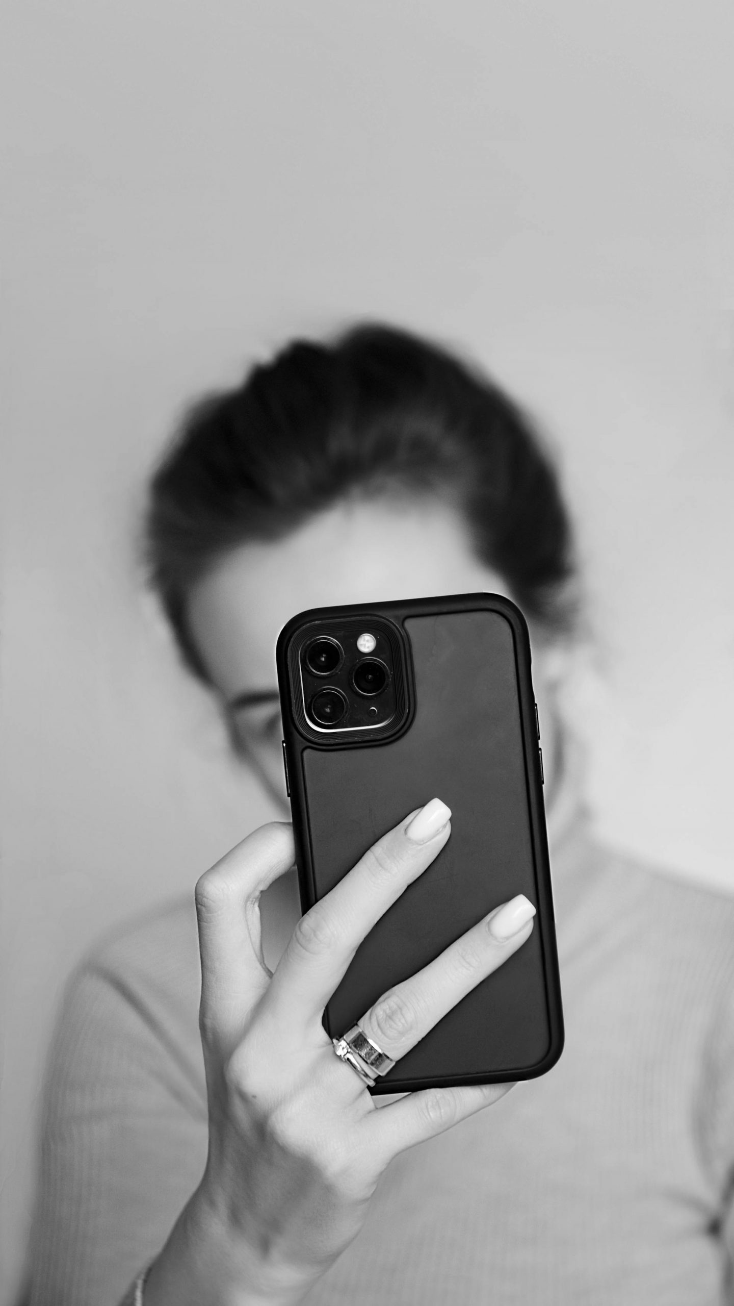 Grayscale shot of a woman holding her phone | Source: Pexels