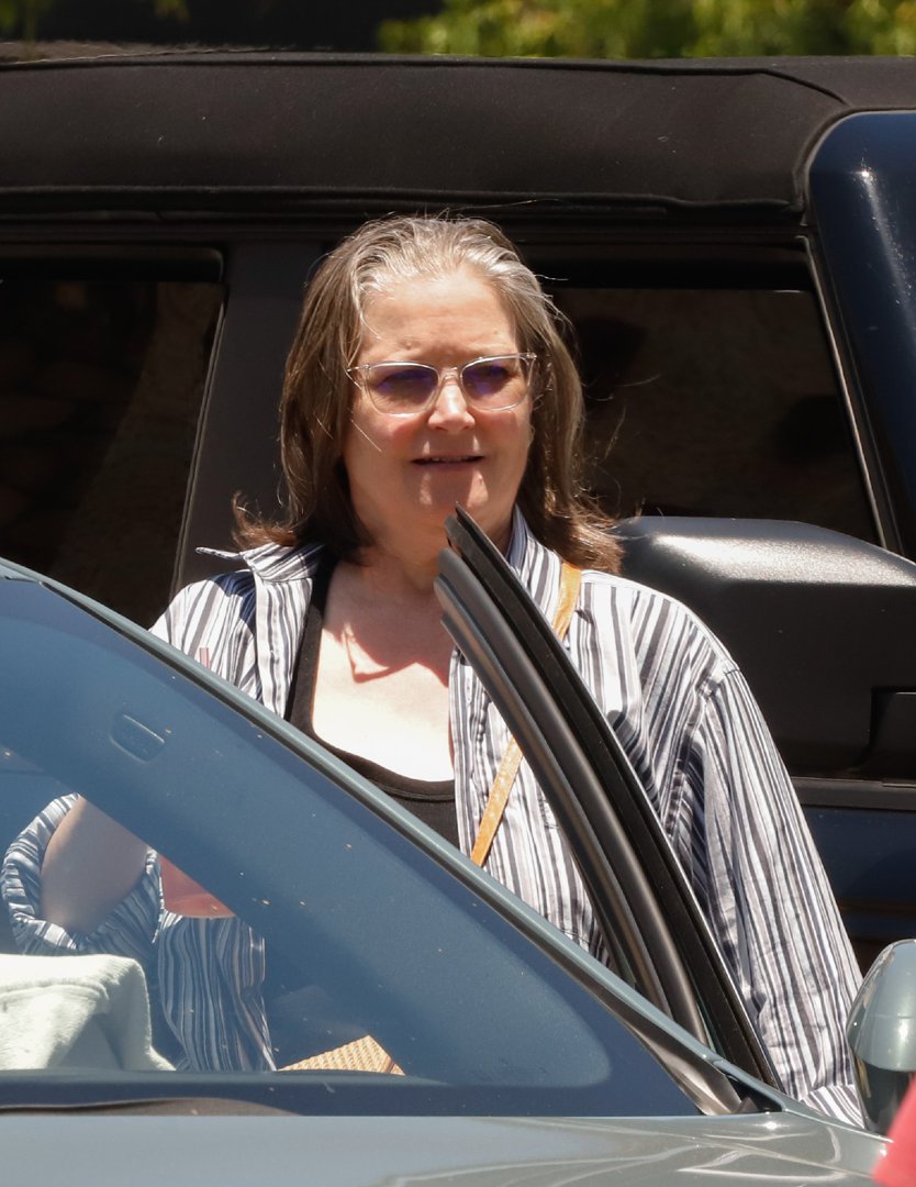 Bridget Fonda was seen on July 1, 2025, in Los Angeles, California, stepping out in a relaxed striped shirt layered over a black top, with a woven crossbody bag slung over her shoulder and tinted glasses framing her face.