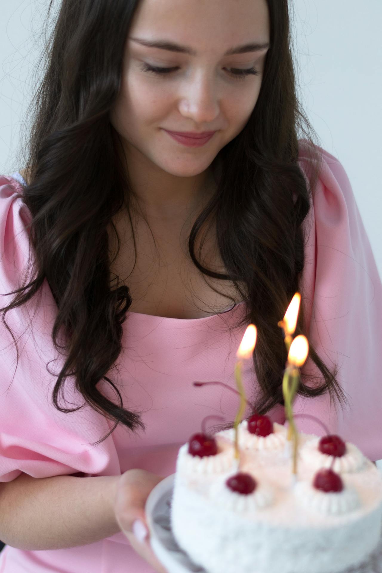 A young woman looking at her birthday cake | Source: Pexels