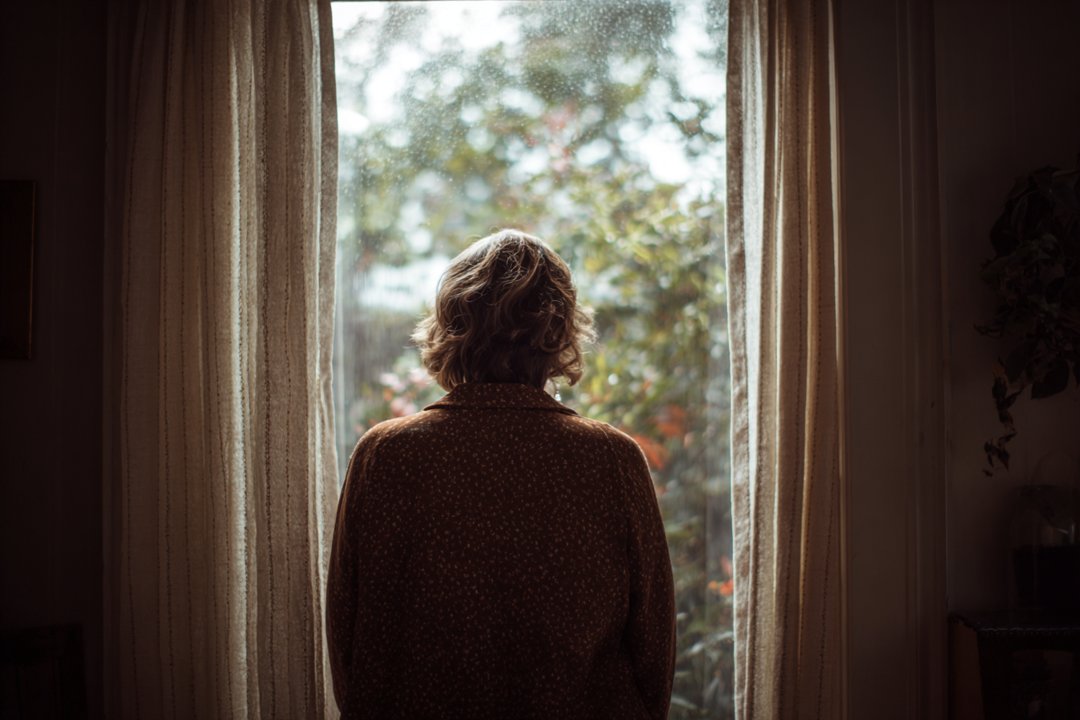 A woman looking out of a window | Source: Midjourney