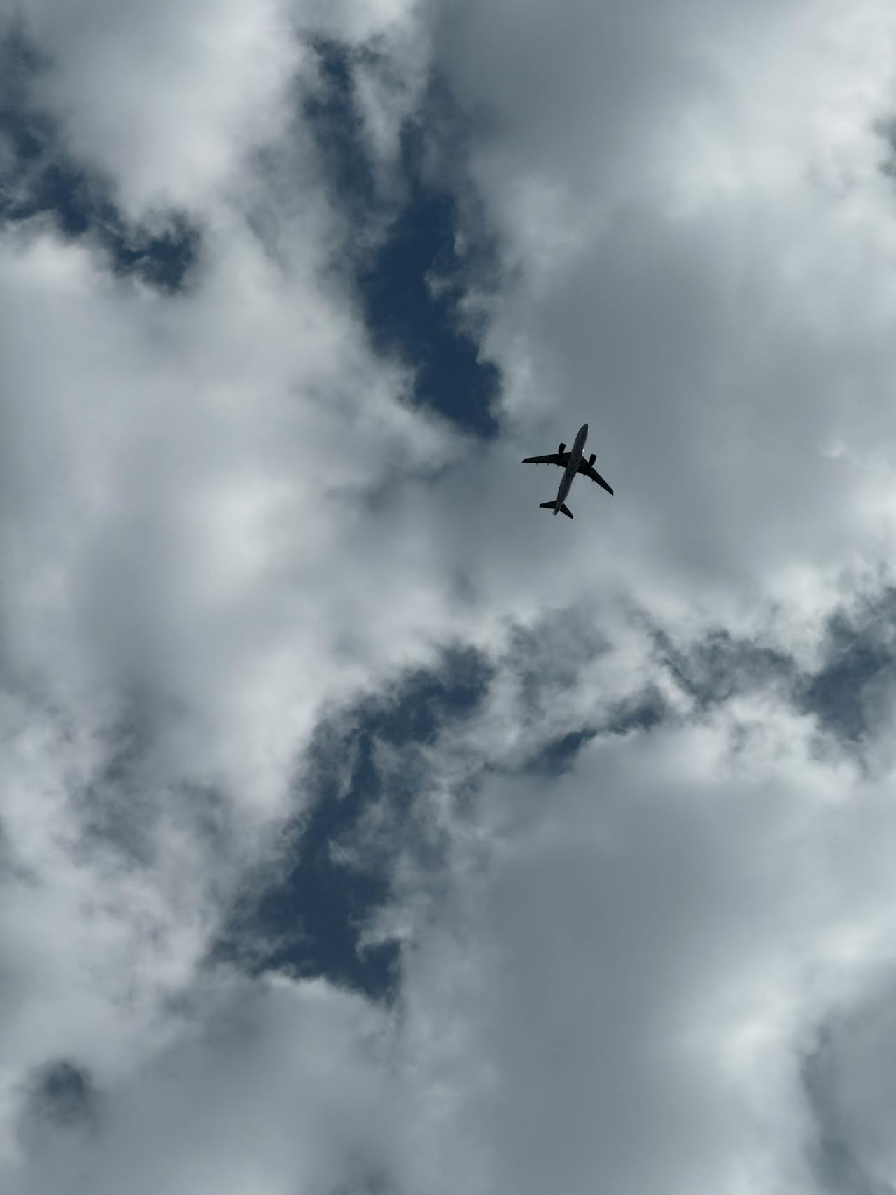 An airplane flying across a cloudy sky | Source: Pexels