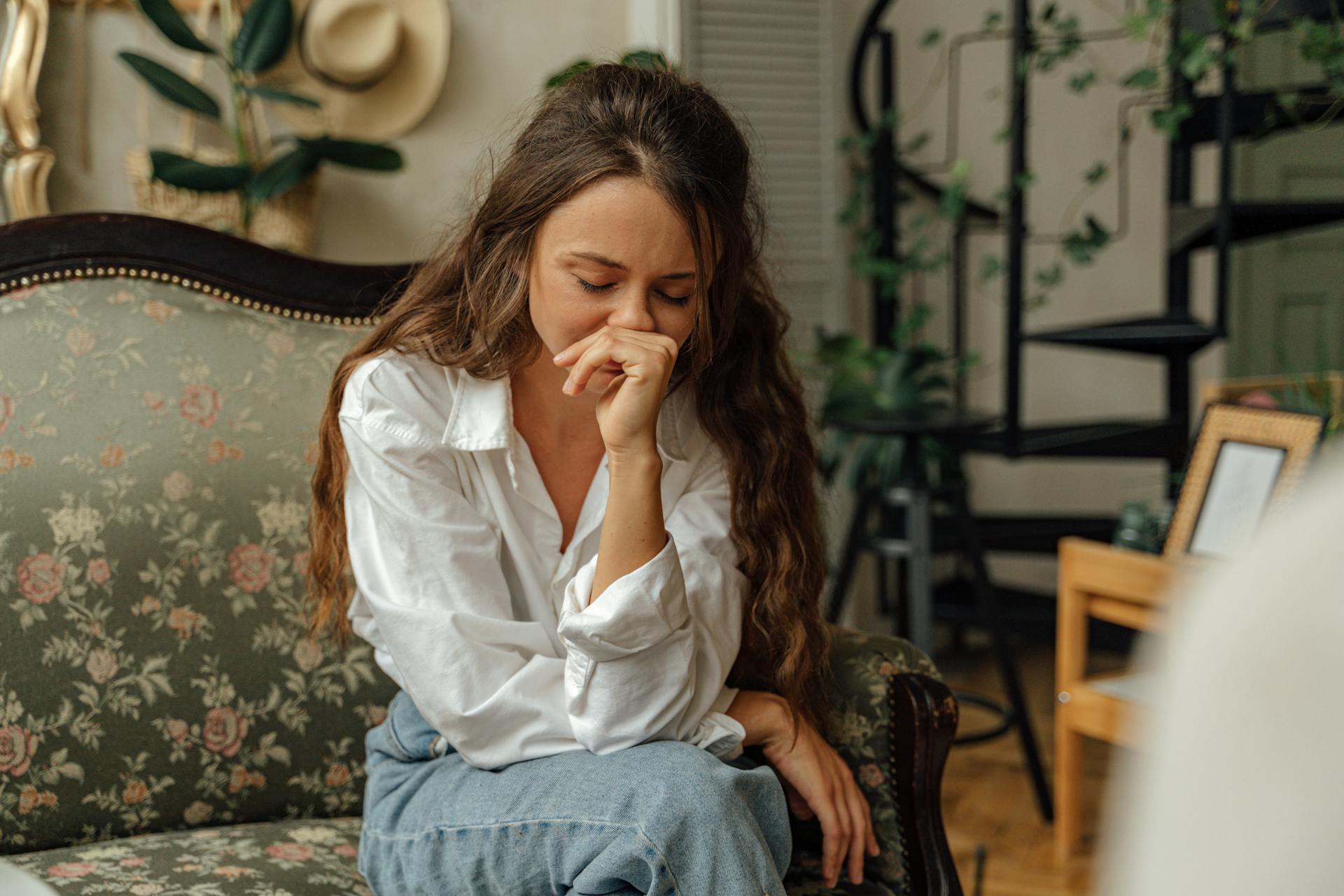 An emotional woman on a couch | Source: Pexels
