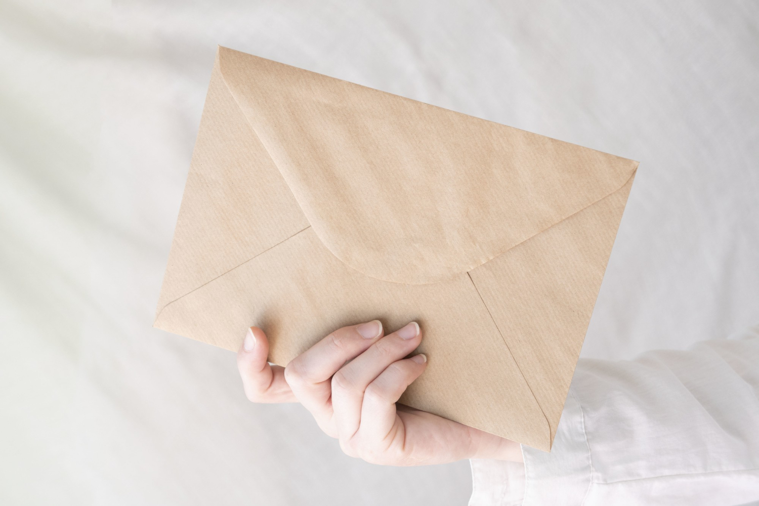 A person holding an envelope | Source: Freepik