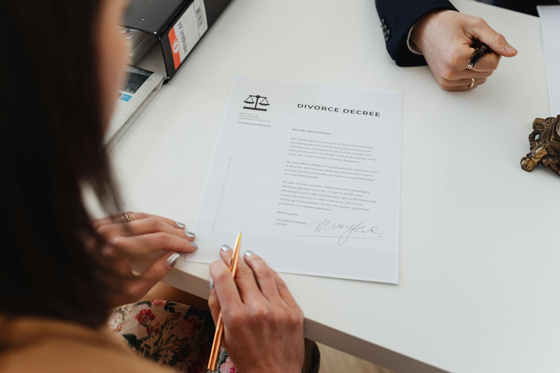 A woman signing a divorce document | Source: Pexels