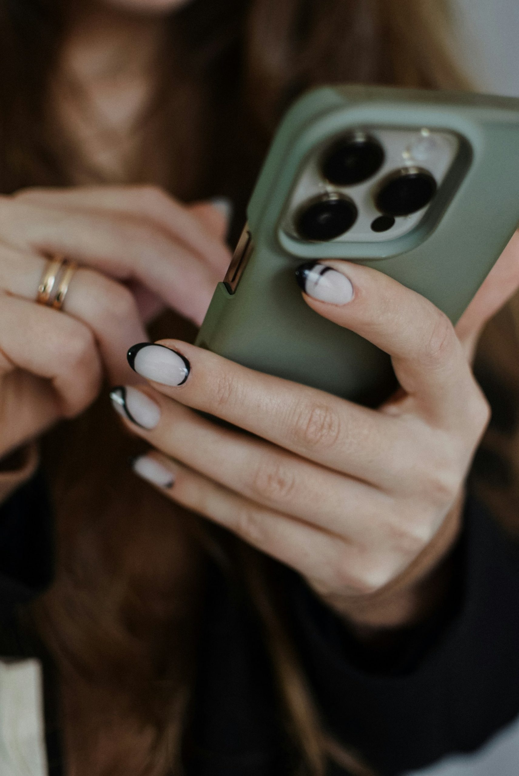 Close-up cropped shot of a woman holding her phone | Source: Unsplash