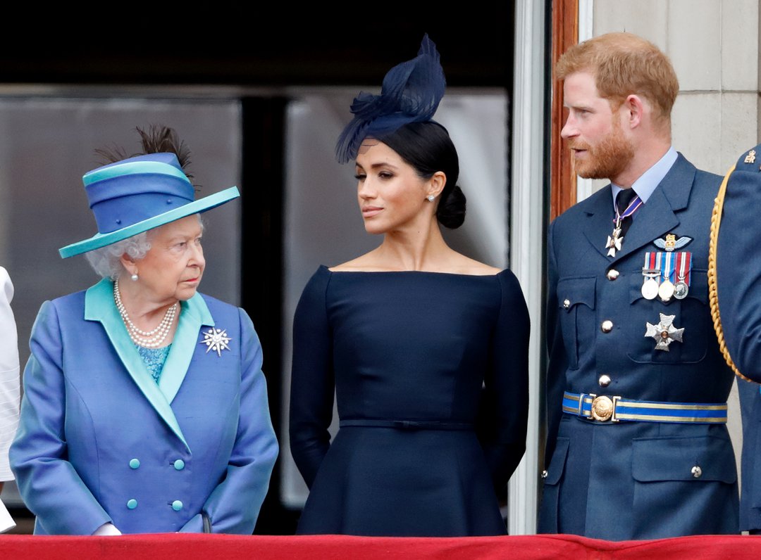 Queen Elizabeth II, Meghan, Duchess of Sussex, and Prince Harry, Duke of Sussex, during the centenary of the Royal Air Force from the balcony of Buckingham Palace on July 10, 2018, in London, England. | Source: Getty Images