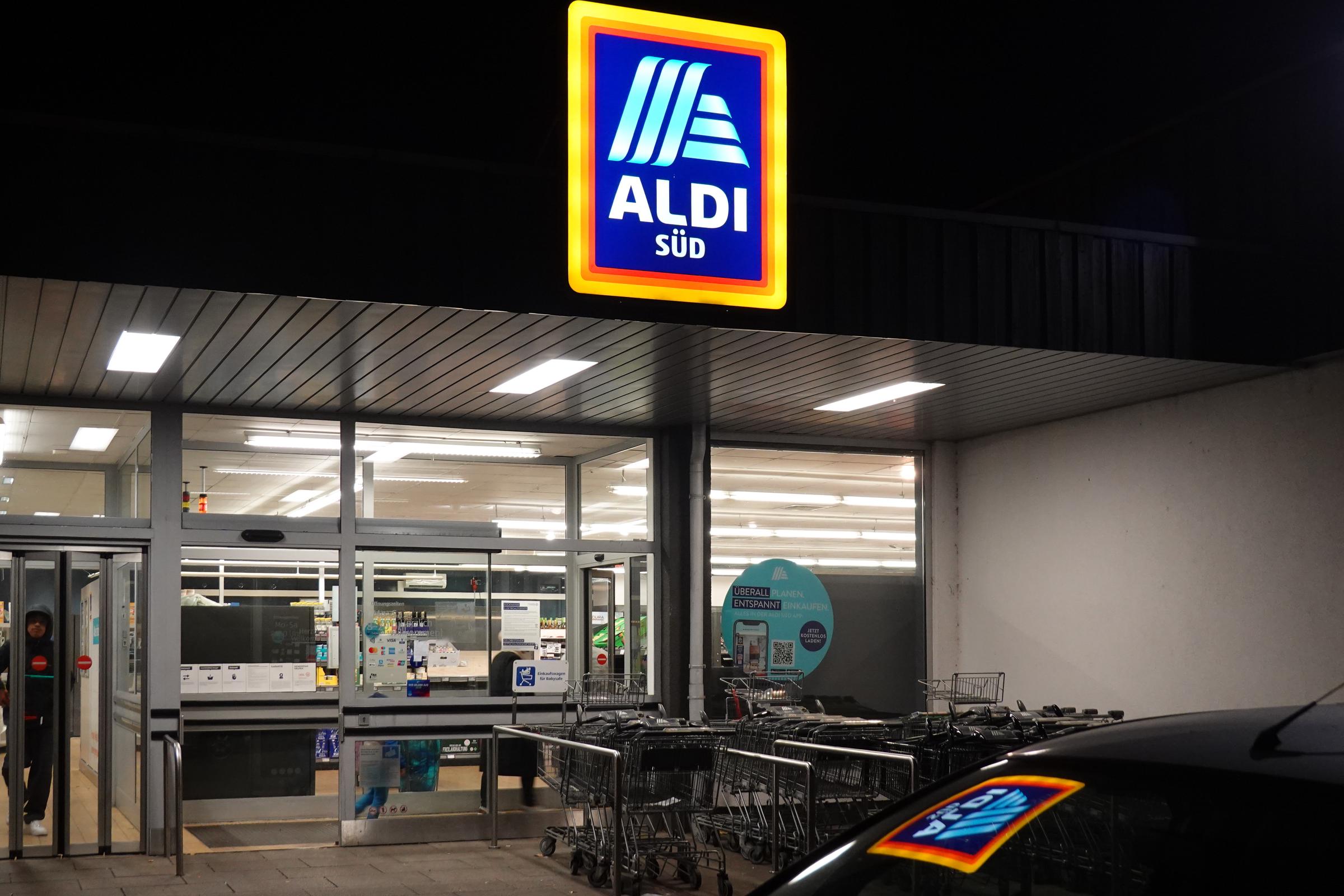 An illuminated Aldi Sued logo is seen above the entrance of an Aldi supermarket. | Source: Getty Images