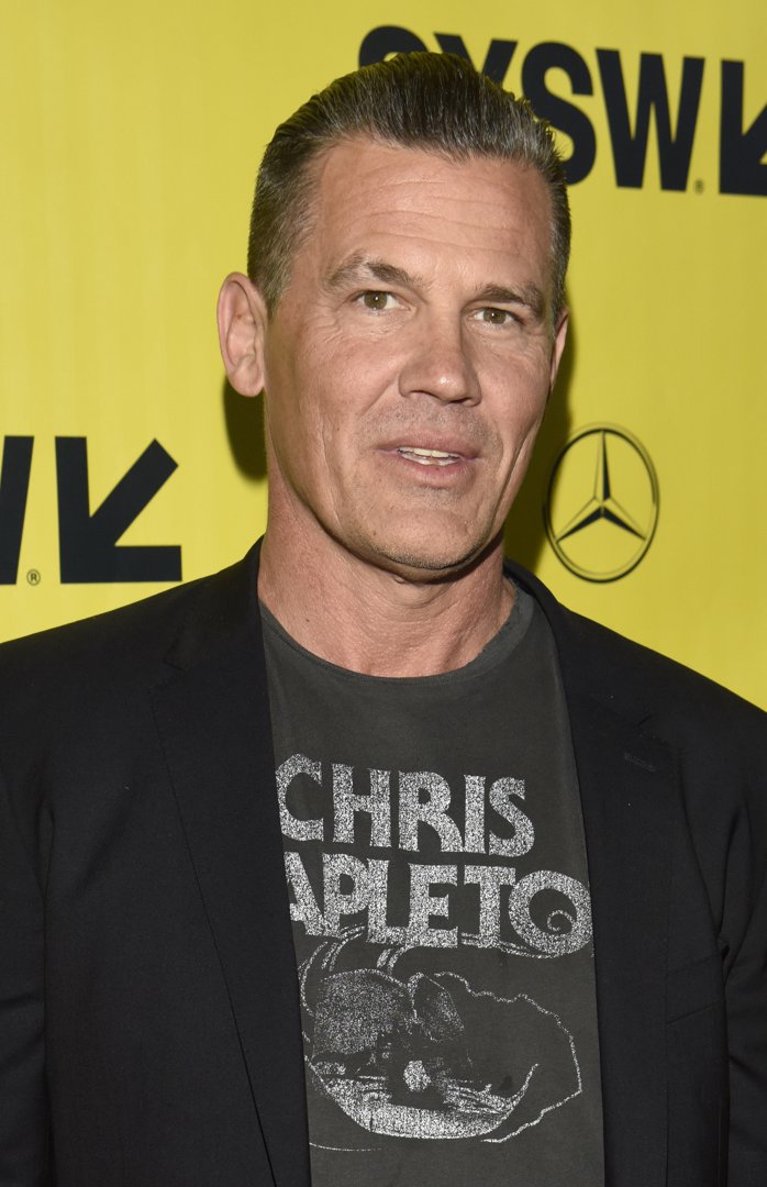 Wearing a graphic T-shirt under a black blazer, Brolin appears clean-shaven with slicked-back hair and a noticeably fuller face — a casual look marking a shift away from formal red carpet styling.