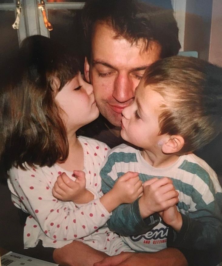 A gentle embrace. A younger Simon is wrapped in pure affection as his son Douglas and his daughter lean in to kiss him on both cheeks. The father of two smiles softly as he accepts the gesture — a timeless snapshot of a father's heart overflowing. | Source: Instagram/douglasbooth