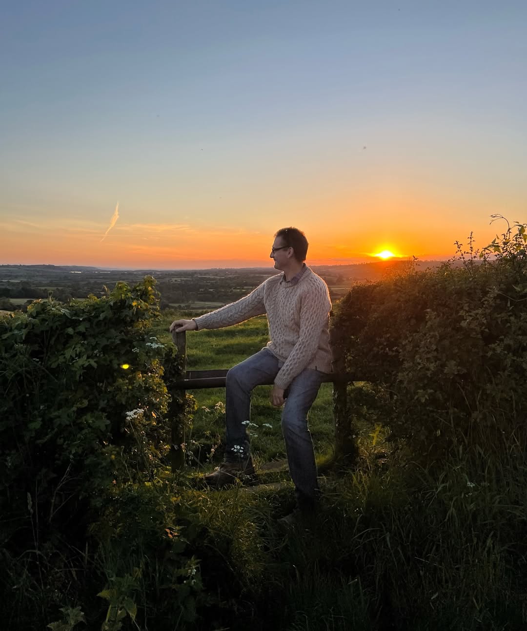 A quiet moment at golden hour. Reflecting on life and landscape, Simon watches the sun dip below the hills — a still, gentle soul in tune with the world around him. | Source: Instagram/douglasbooth