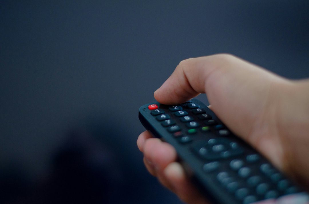 A hand holding a remote controller | Source: Unsplash