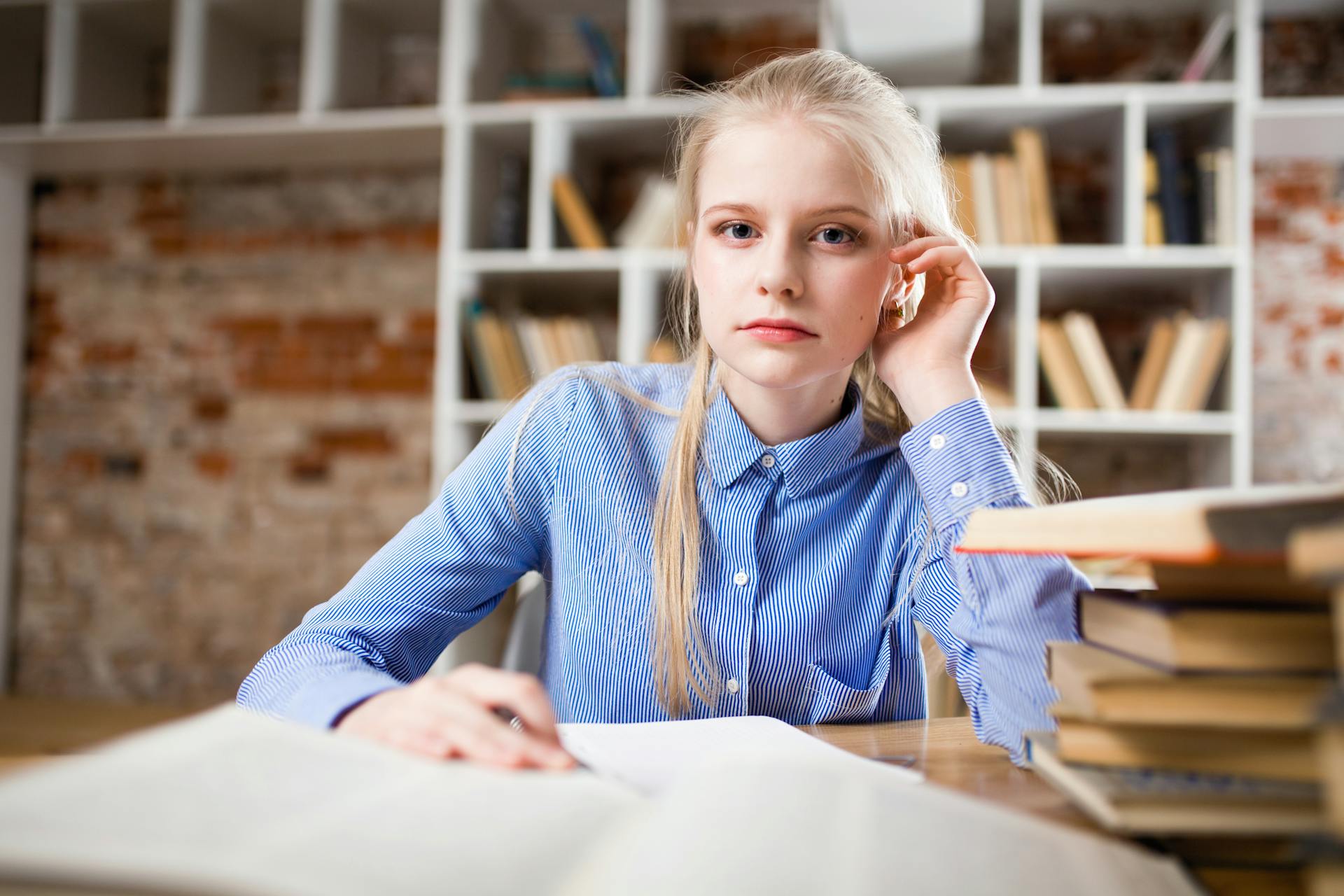 A young woman sitting in a library | Source: Pexels