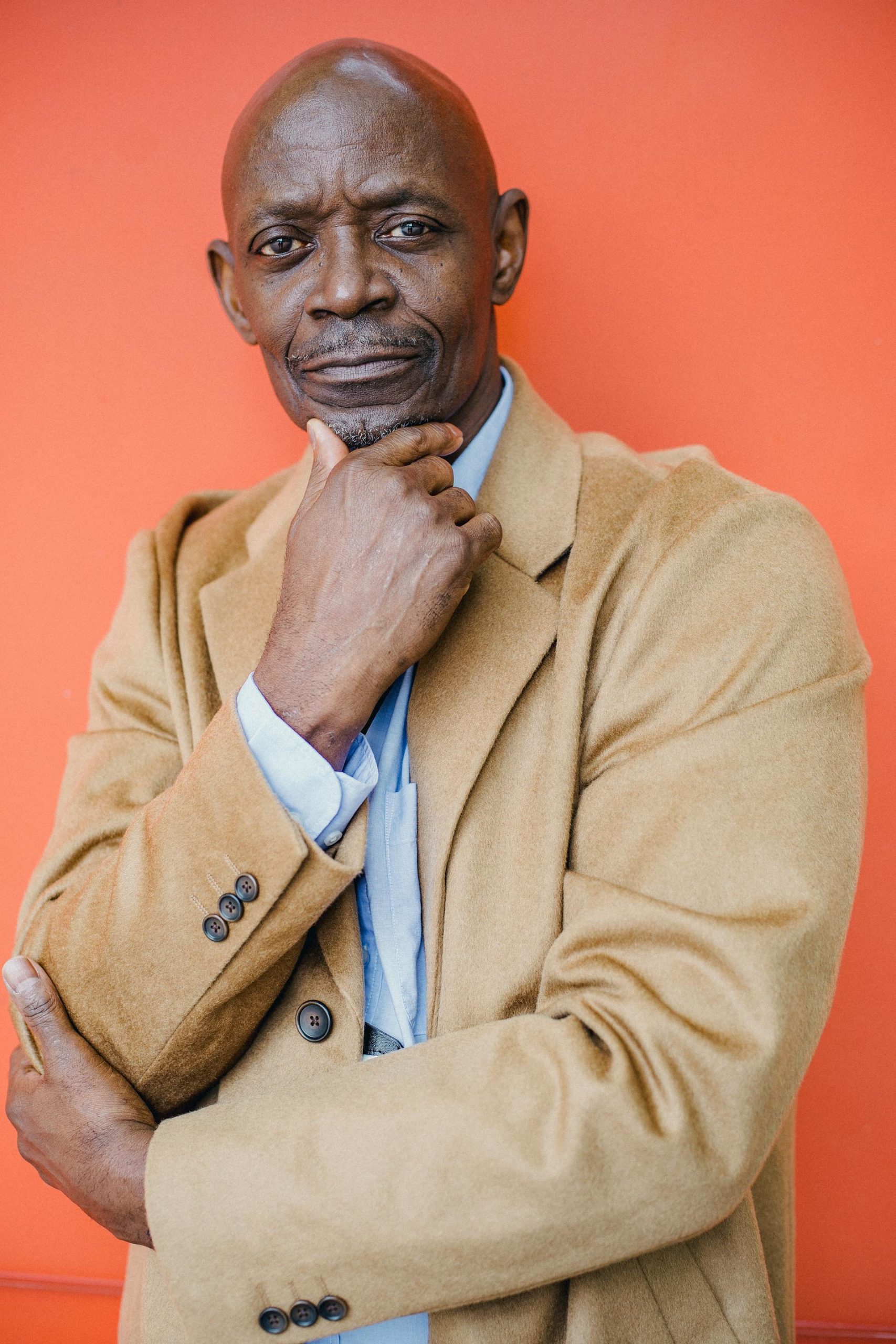 A black man in a coat looking at someone | Source: Pexels