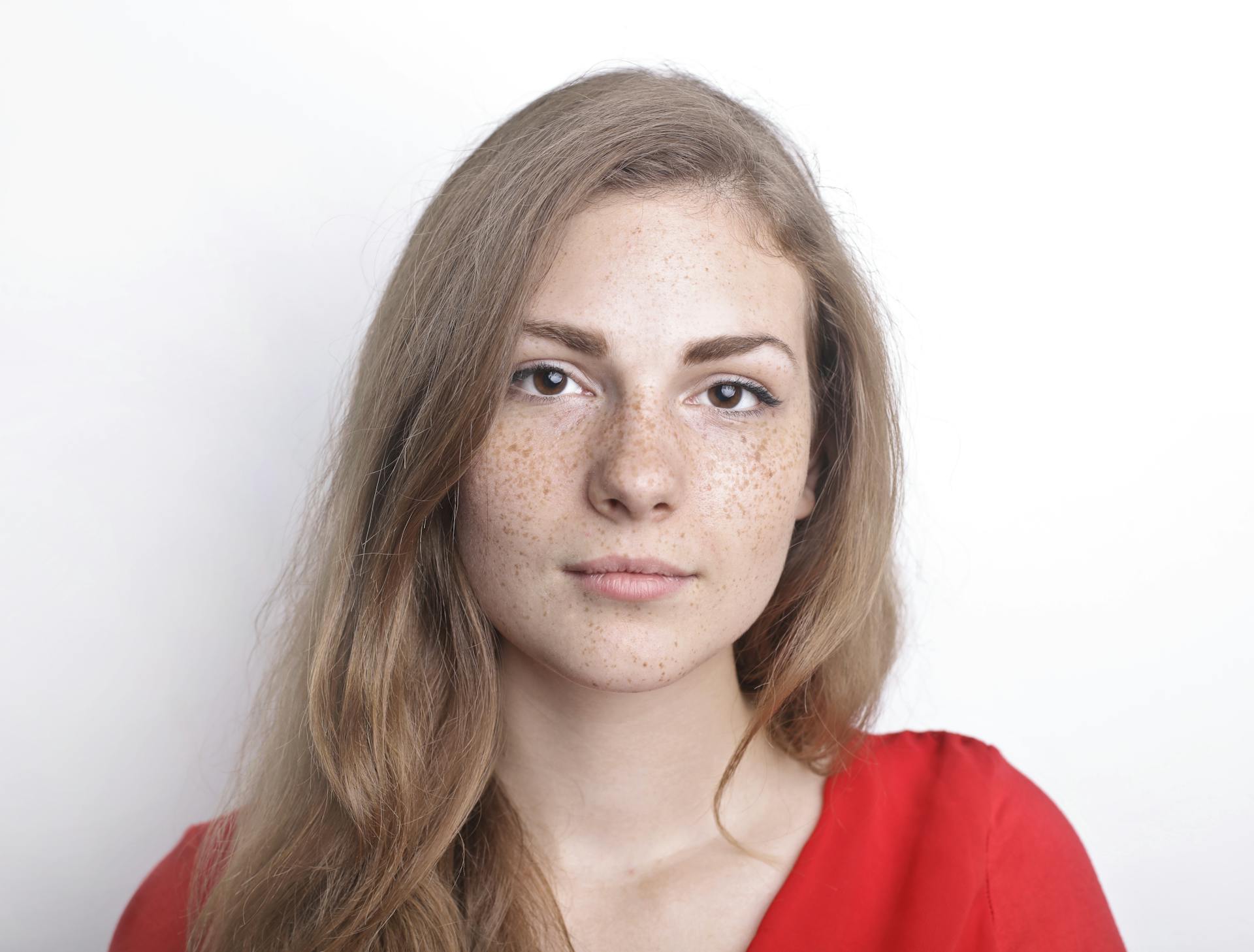 A young woman with freckles looking straight ahead | Source: Pexels