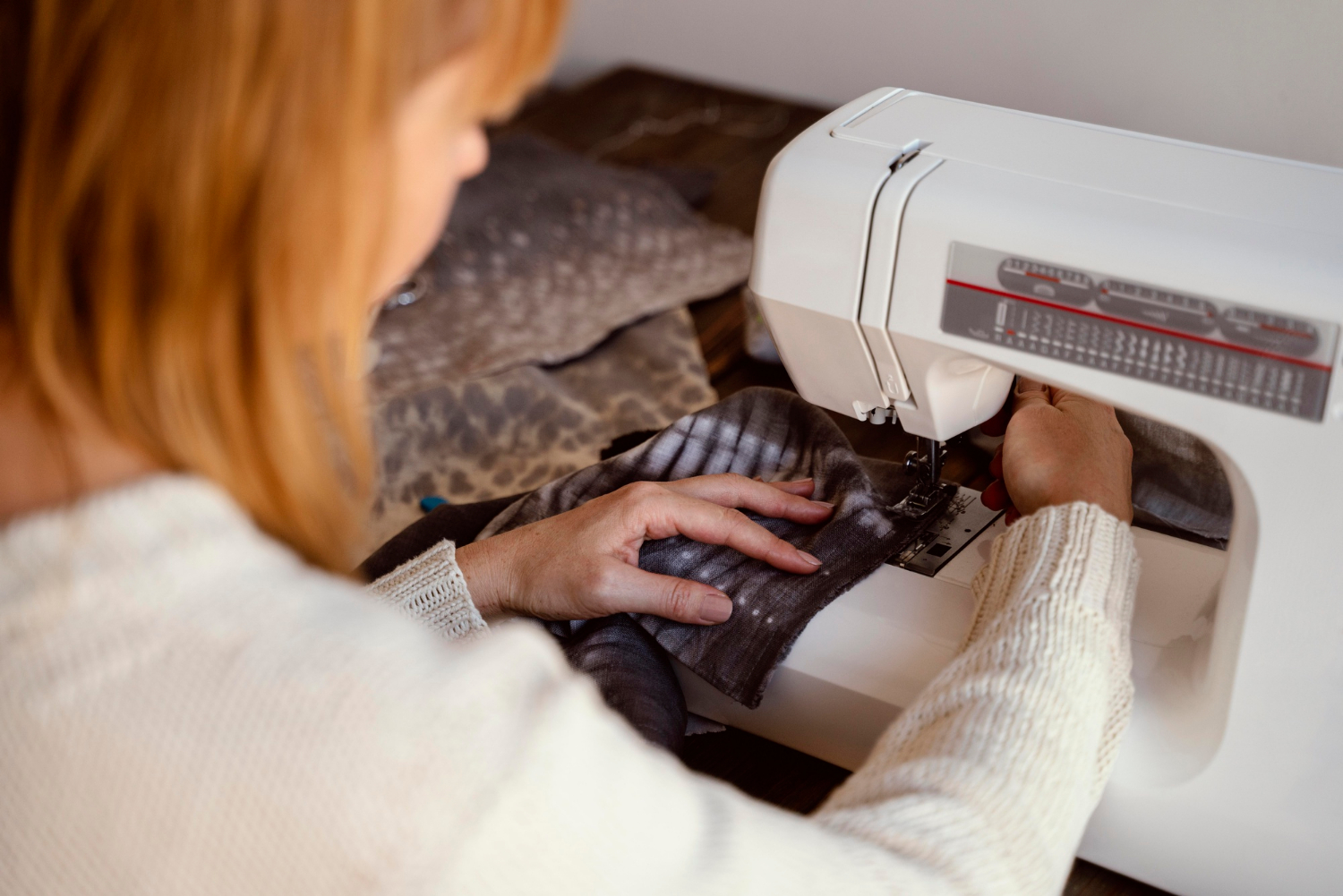 A woman using a sewing machine | Source: Freepik