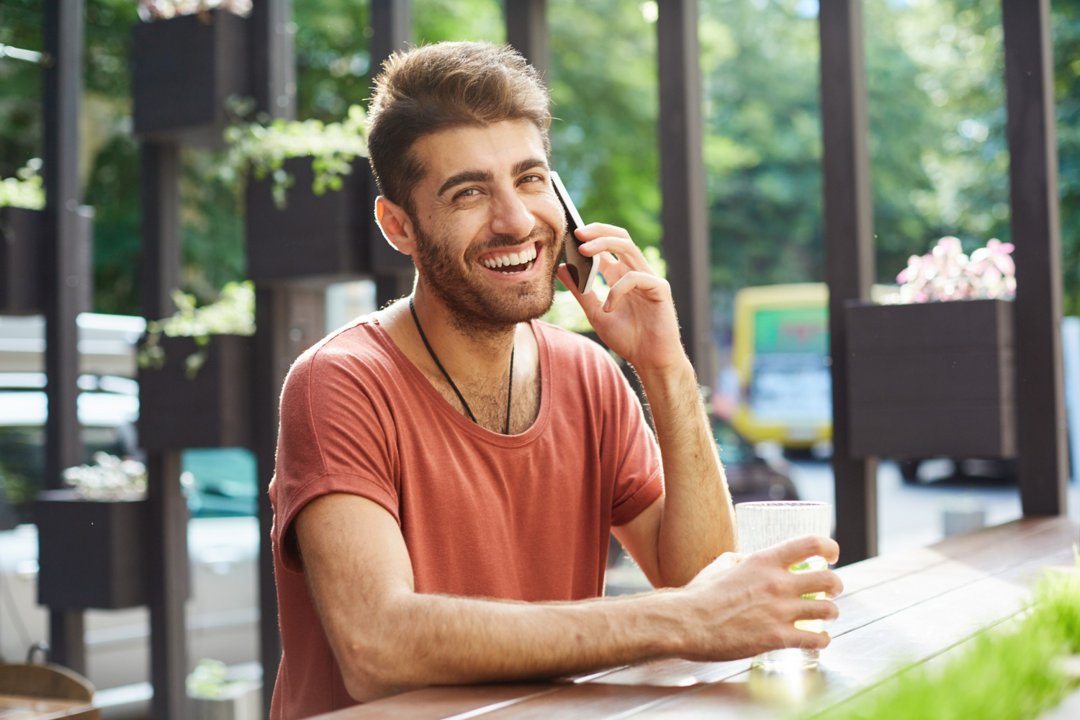 A happy man talking on the phone | Source: Freepik